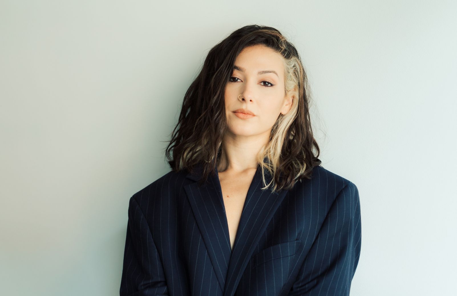 A woman in a blue blazer, against a white background