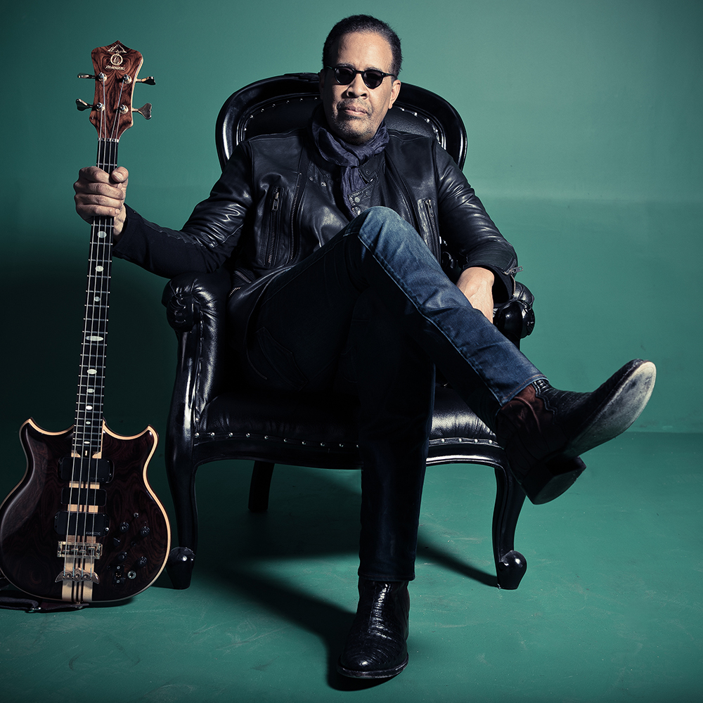 Stanley Clarke sitting in a chair with his bass